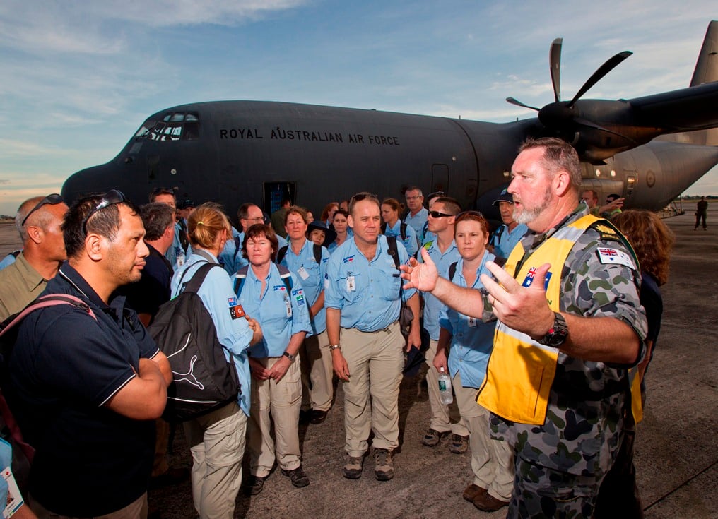 Once disembarked from the RAAF C-130J Hercules, Australian Official, Navy Warrant Officer Chuck Connors of the Australian Embassy(right), welcomes the civilian AusMAT on their arrival at Mactan-Cebu. (Photo: CPL Glen McCarthy ©Commonwealth of Australia, Department of Defence)